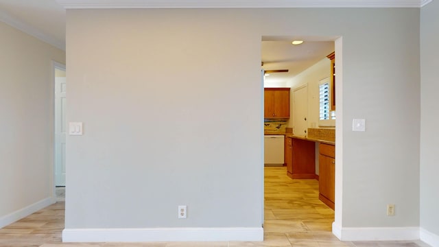 interior space with light wood-type flooring, baseboards, and crown molding