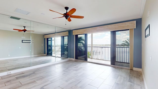 empty room featuring baseboards, crown molding, visible vents, and a ceiling fan