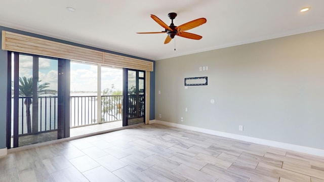 empty room with ceiling fan, ornamental molding, and baseboards