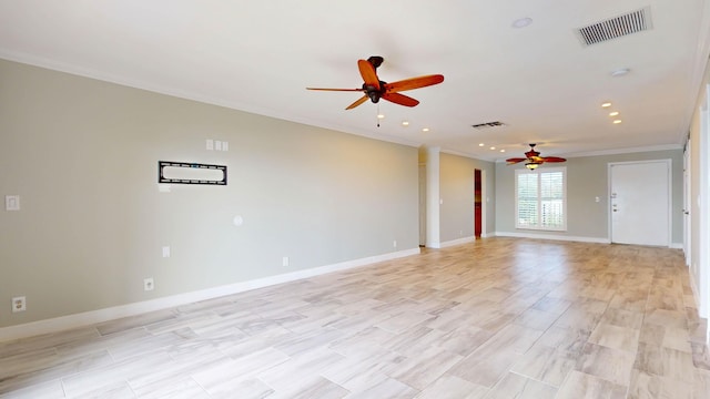 spare room featuring baseboards, visible vents, ceiling fan, and ornamental molding