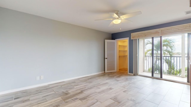 spare room with visible vents, ceiling fan, and baseboards