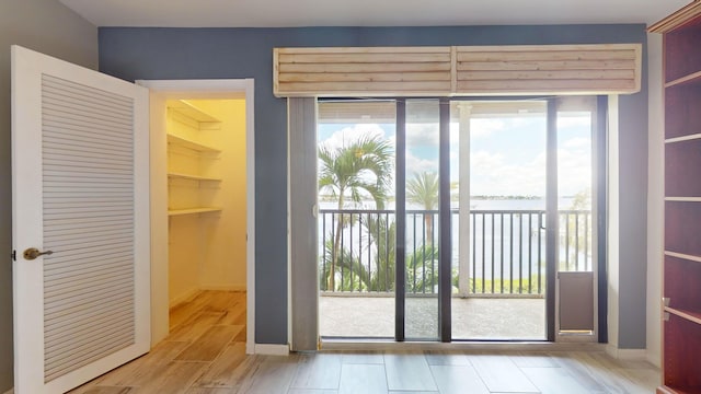 doorway featuring a water view and light wood finished floors