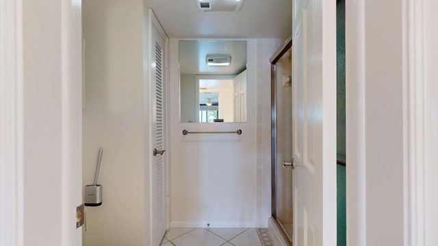 hallway with light tile patterned floors and baseboards