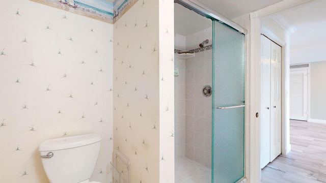 full bath featuring a stall shower, toilet, and wood finished floors