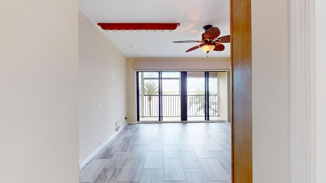 spare room with ceiling fan and baseboards