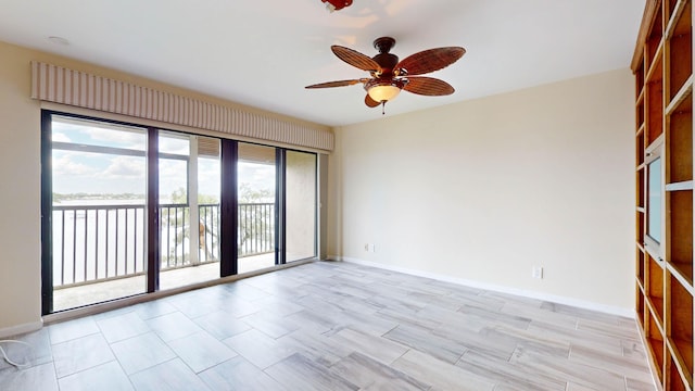 empty room featuring ceiling fan and baseboards