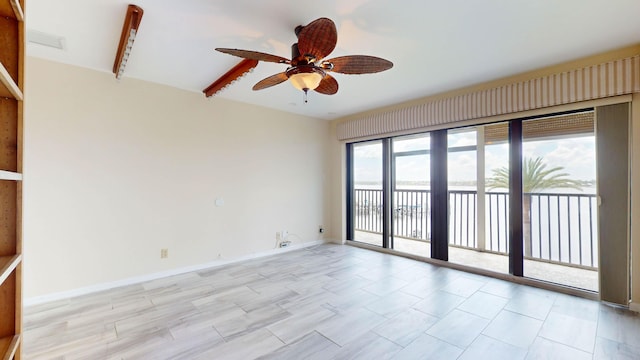 spare room featuring ceiling fan and baseboards