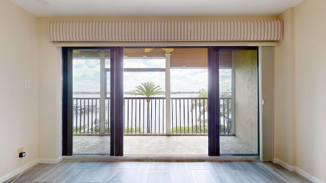 entryway with a water view, plenty of natural light, and baseboards