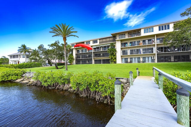 dock area with a water view and a yard