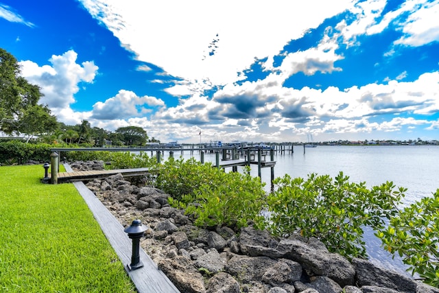 view of dock featuring a yard and a water view