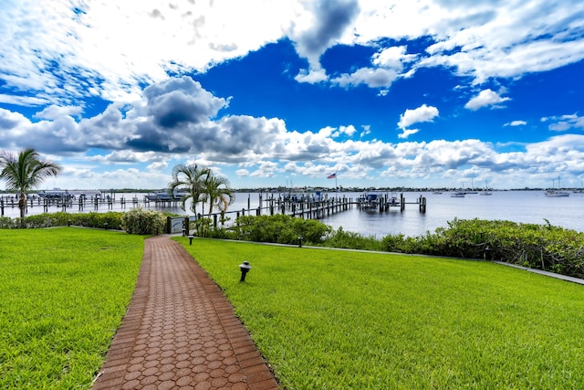 dock area with a water view and a yard