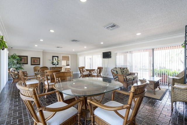 dining space with ornamental molding, recessed lighting, brick floor, and visible vents