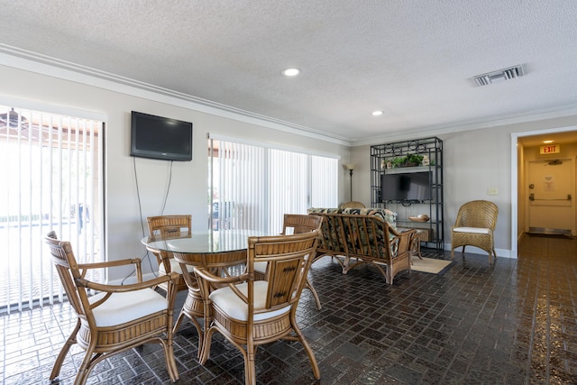 dining space featuring ornamental molding, a healthy amount of sunlight, visible vents, and brick floor