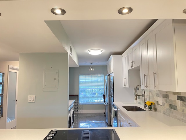 kitchen with sink, electric panel, washer / dryer, decorative backsplash, and white cabinets