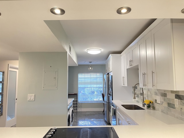 kitchen featuring a sink, light countertops, white cabinets, backsplash, and baseboards