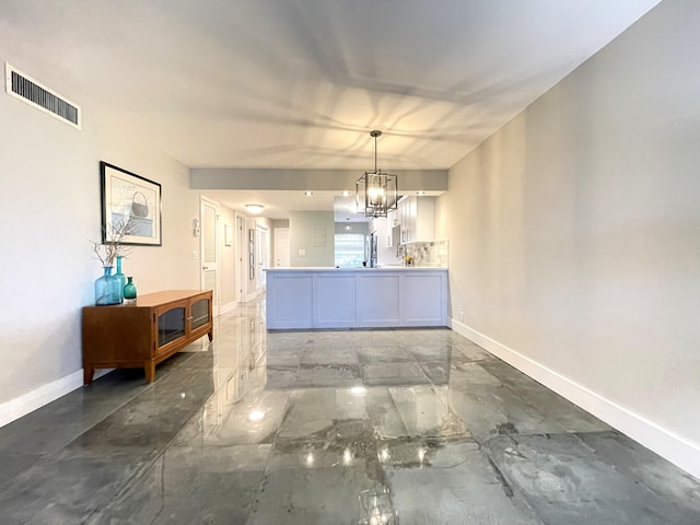 unfurnished dining area featuring a notable chandelier