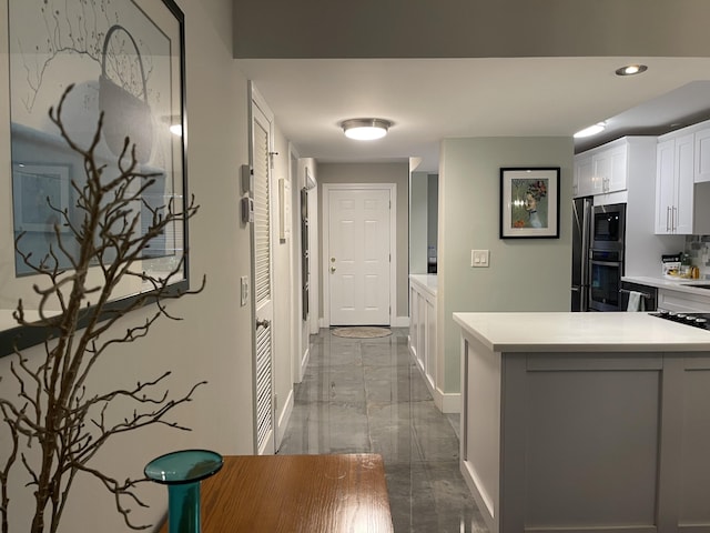 corridor with marble tiled floors, baseboards, and recessed lighting
