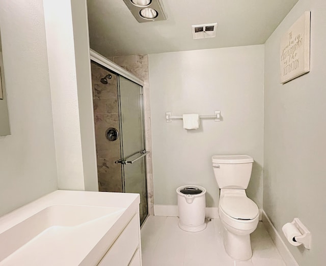 bathroom featuring tile patterned floors, vanity, toilet, and a shower with door