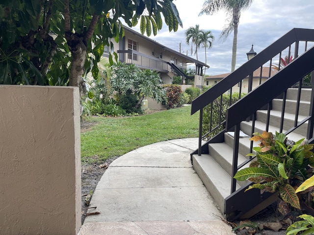 view of grassy yard featuring stairway