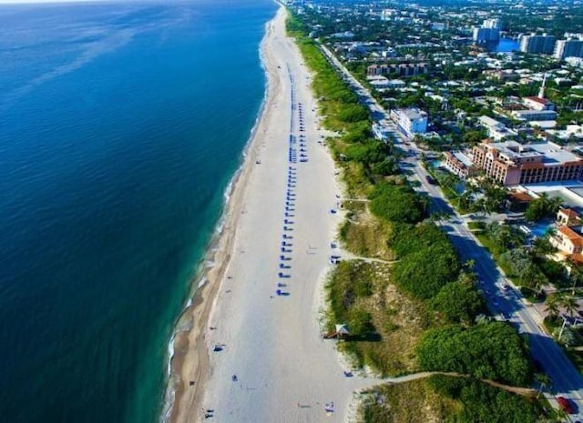 birds eye view of property with a water view and a beach view