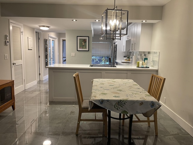 dining space featuring a notable chandelier and sink