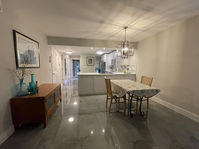 dining area featuring sink and a chandelier