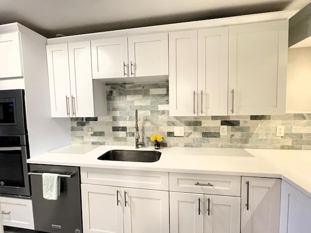 kitchen with backsplash, white cabinetry, sink, and appliances with stainless steel finishes