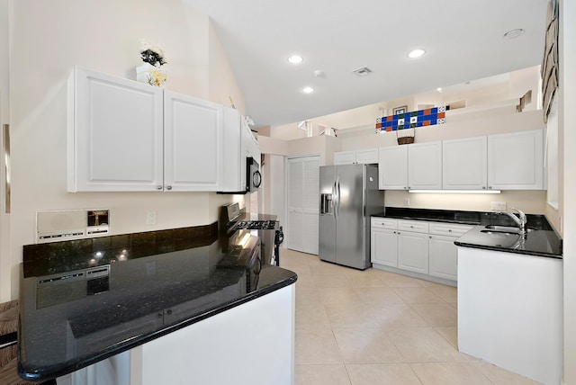 kitchen with stainless steel appliances, white cabinets, sink, light tile patterned flooring, and high vaulted ceiling