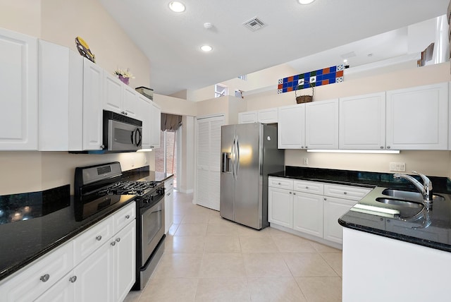 kitchen with dark stone counters, white cabinetry, and appliances with stainless steel finishes