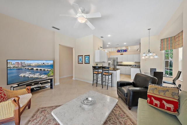 living room featuring ceiling fan with notable chandelier and light tile patterned floors