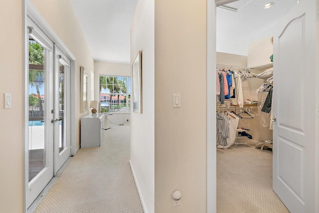 corridor with french doors and light colored carpet