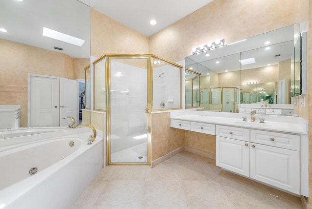 bathroom with a skylight, independent shower and bath, tile patterned floors, and vanity