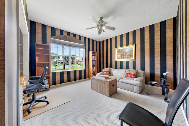 office area featuring carpet, ceiling fan, and a textured ceiling