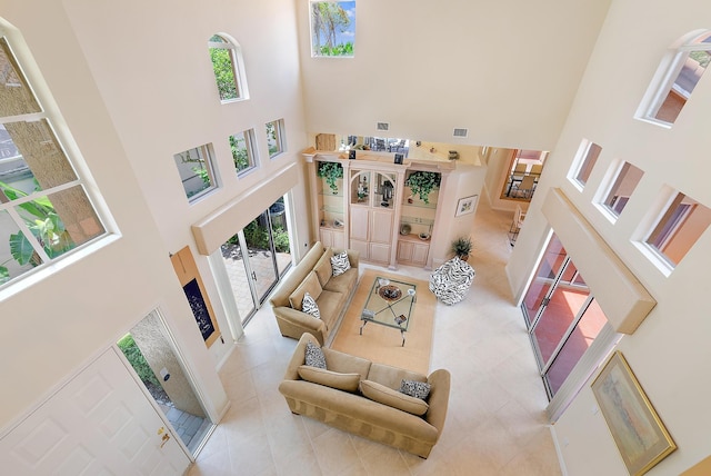 tiled living room with a towering ceiling