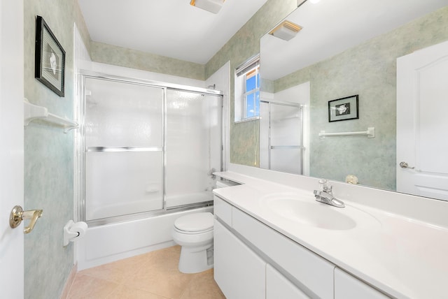 full bathroom featuring combined bath / shower with glass door, tile patterned floors, toilet, and vanity