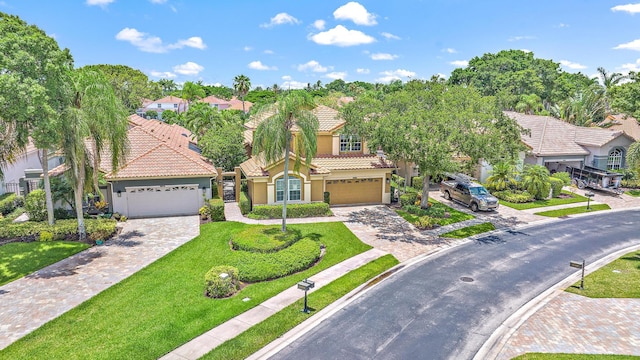 mediterranean / spanish-style house featuring a garage and a front yard