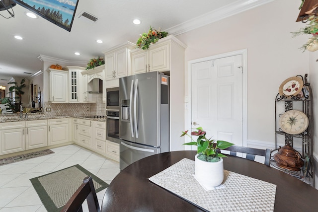 kitchen with wall chimney exhaust hood, crown molding, light tile patterned floors, stainless steel appliances, and light stone countertops