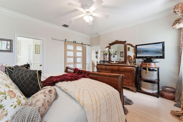 bedroom with ornamental molding, a barn door, ceiling fan, and light wood-type flooring