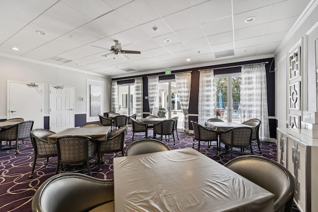 dining area featuring dark colored carpet, ornamental molding, and ceiling fan