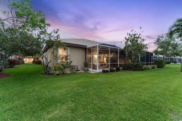 exterior space featuring a yard and glass enclosure