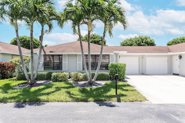 single story home with a front yard and a garage