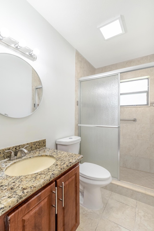 bathroom with tile patterned floors, vanity, toilet, and a shower with shower door