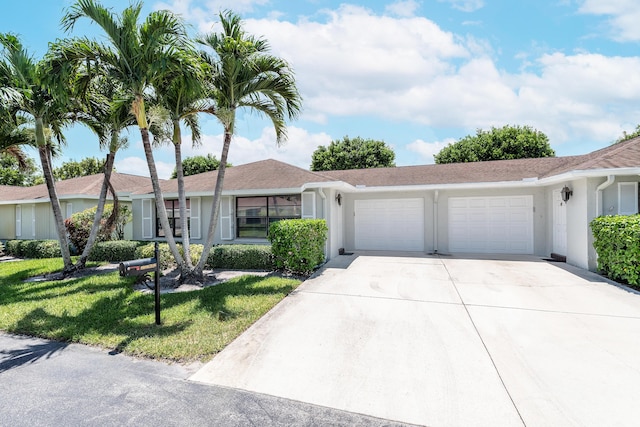 single story home featuring a garage and a front lawn