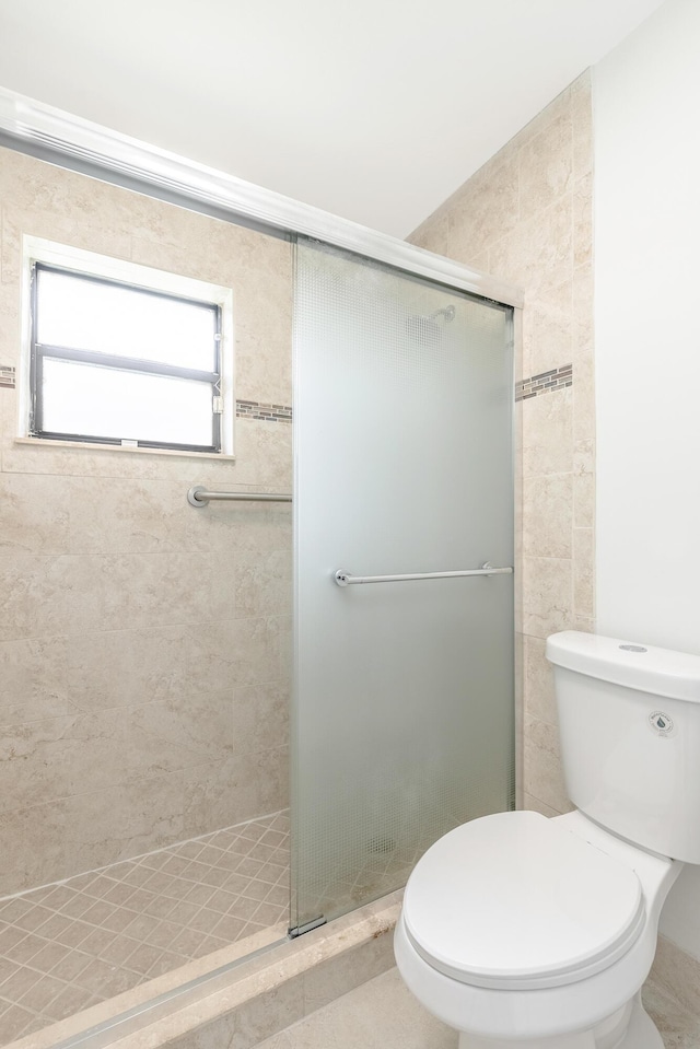 bathroom with an enclosed shower and toilet