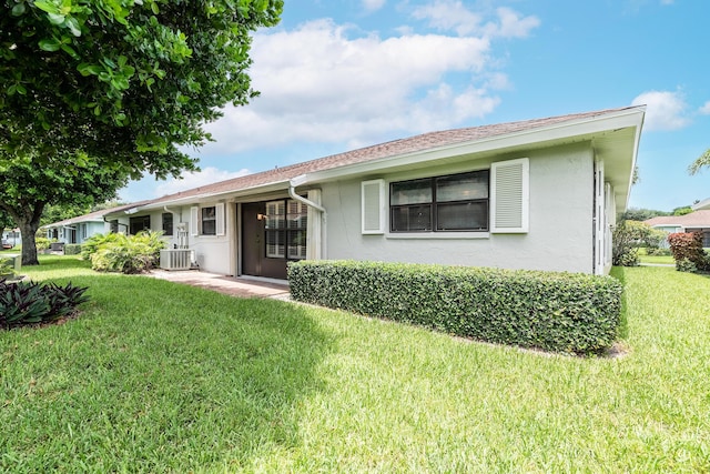 rear view of property featuring a lawn and central AC