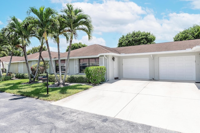 ranch-style house with a garage and a front lawn