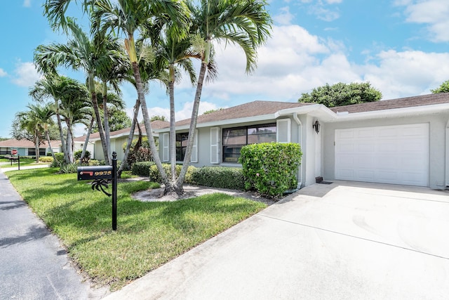 ranch-style home with a garage and a front lawn