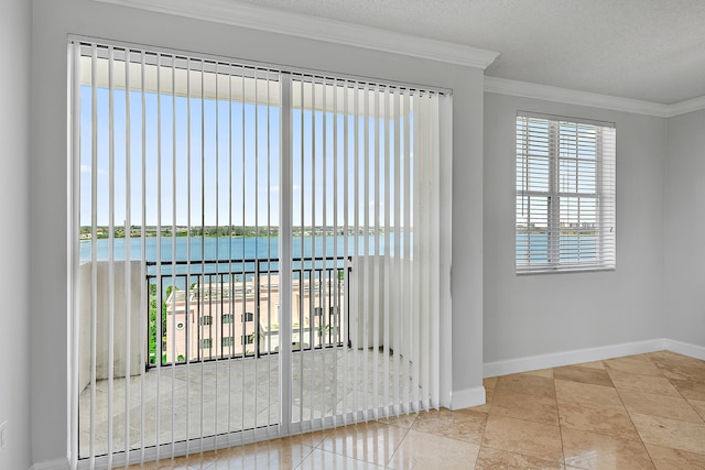 interior space featuring a water view, tile patterned flooring, ornamental molding, and a textured ceiling