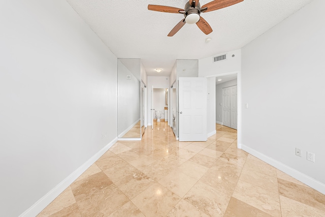 unfurnished bedroom featuring light tile patterned flooring, a textured ceiling, and ceiling fan