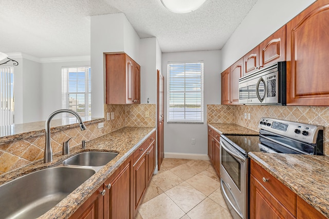 kitchen with tasteful backsplash, stone counters, appliances with stainless steel finishes, and sink